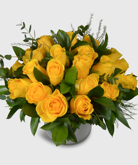 Yellow roses designed in a short white cylinder with a assorted greenery-Two dozen yellow roses shown