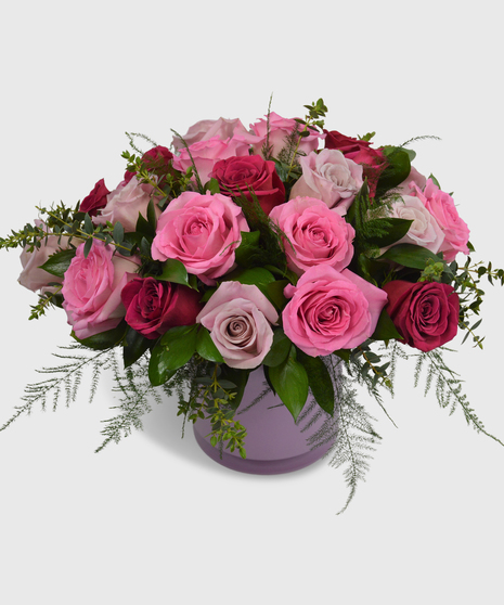 Pink, purple and red roses designed in a short cylinder vase