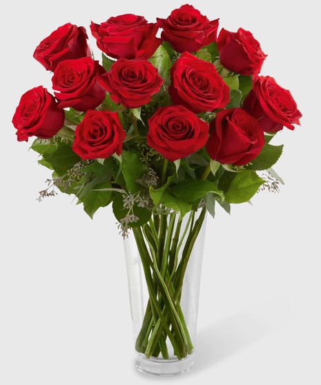 Long stemmed red roses in a stylish glass vase. 