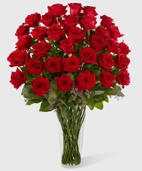 Long stemmed red roses in a stylish glass vase. 