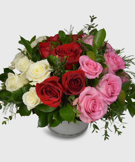 A mix of white, pink and red roses designed in a short white cylinder with a assorted greenery-Two dozen roses shown