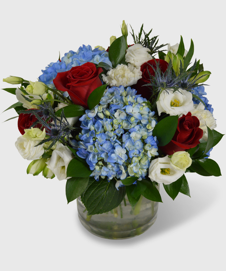 A patriotic vase full of red, white and blue flowers